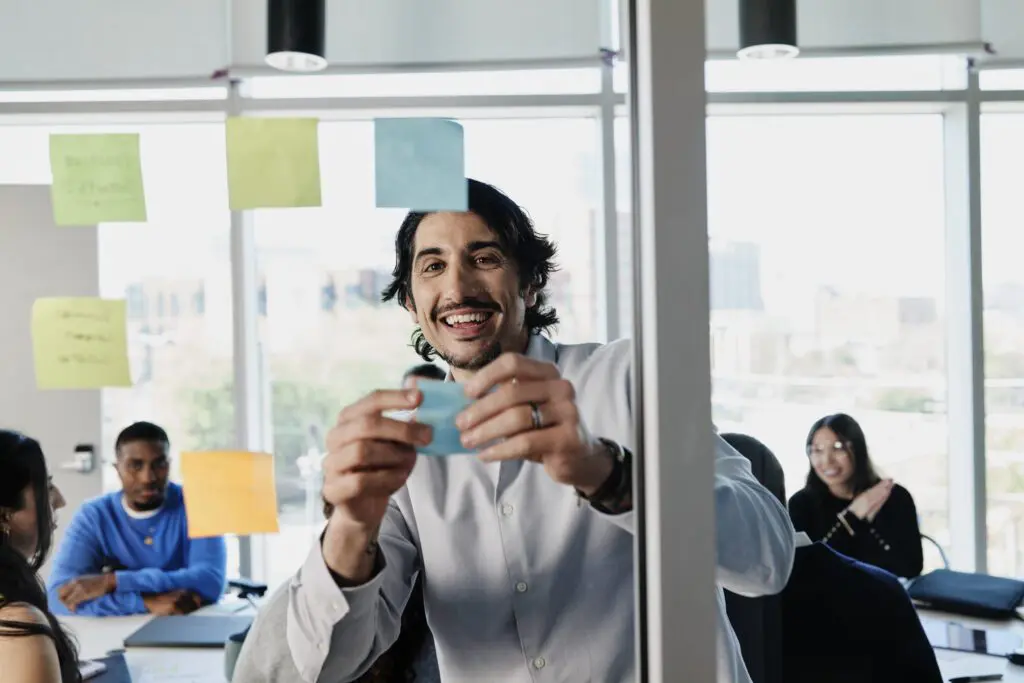 man placing sticky notes on board