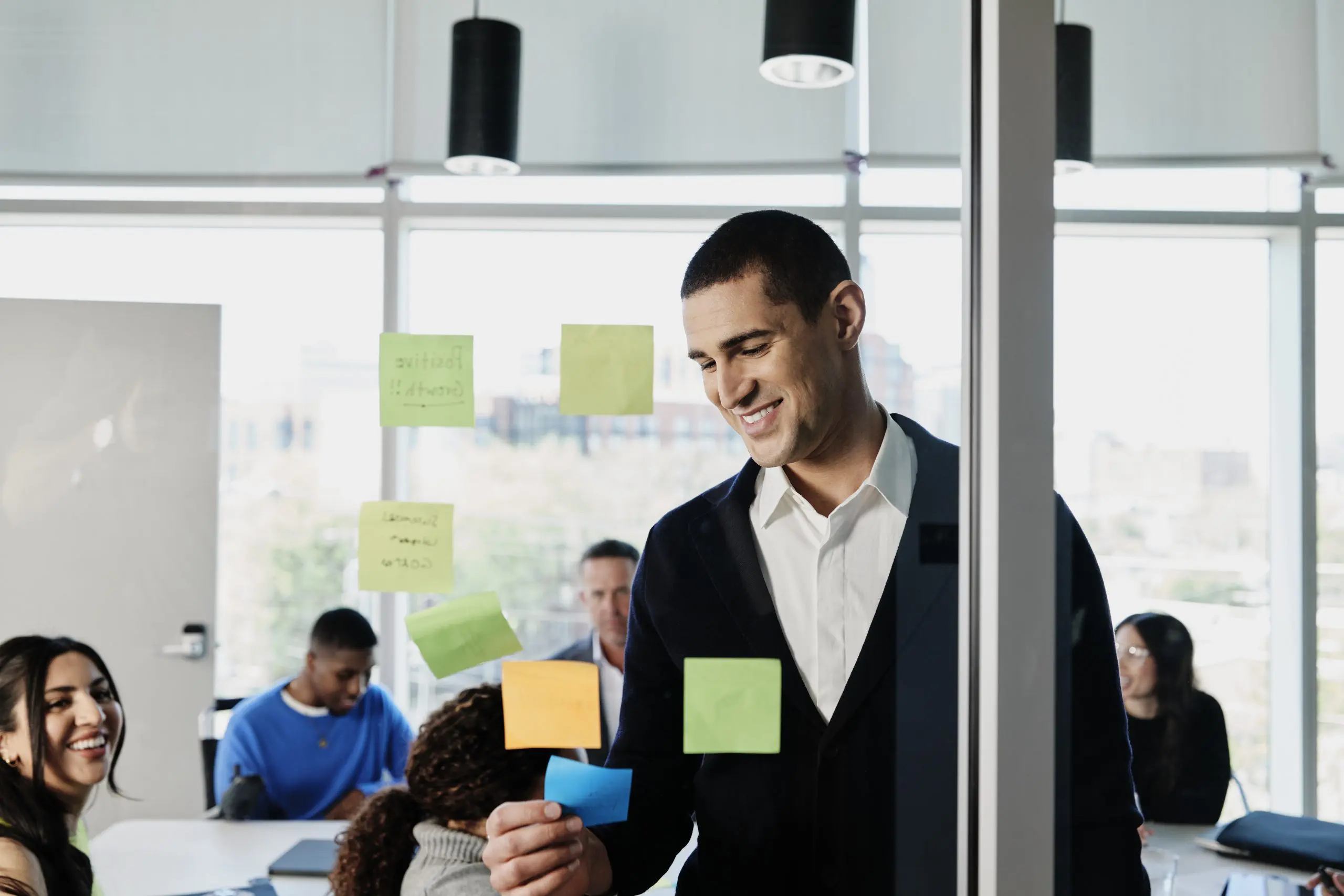 man putting sticky notes on board