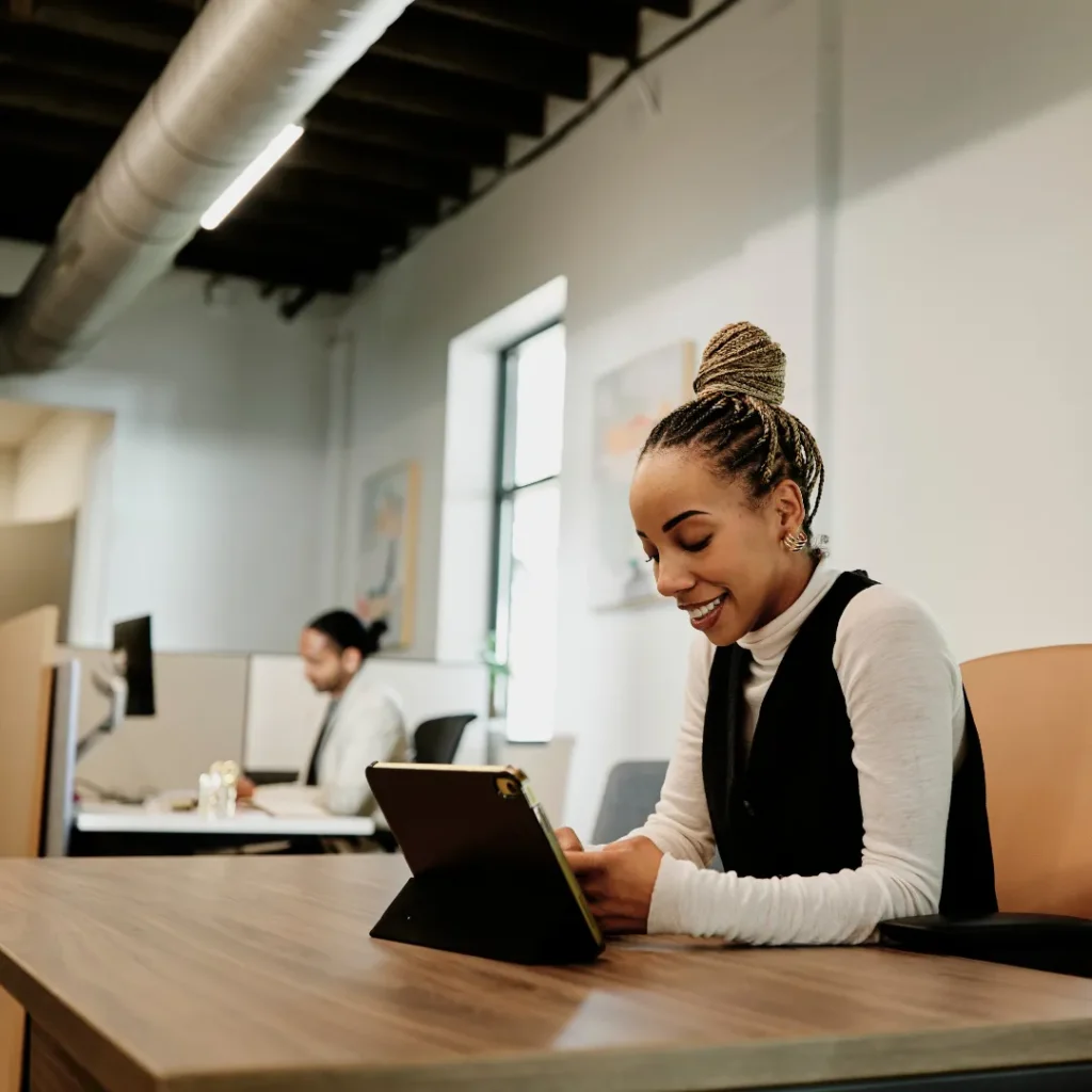 Employee works on tablet at desk.