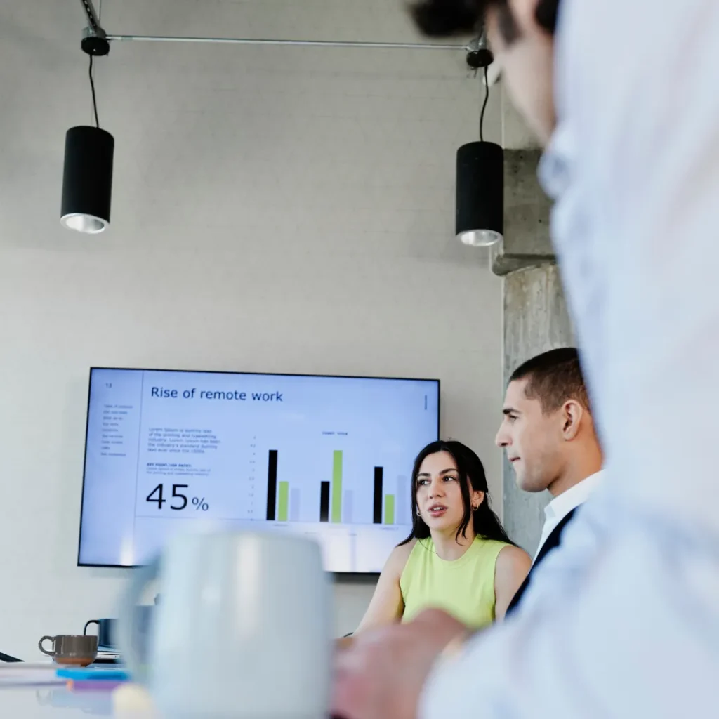 Colleagues go over their presentation in a conference room.