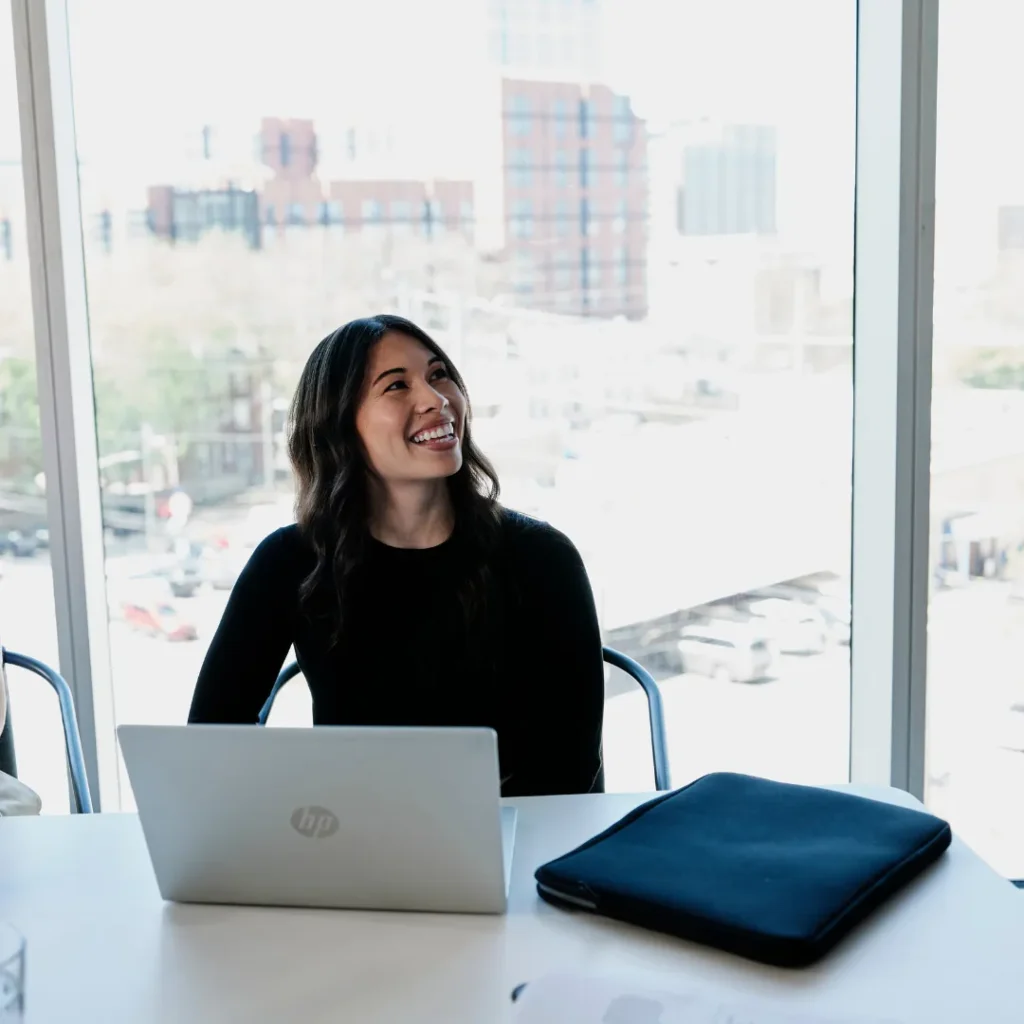 Smiling women sits with her laptop