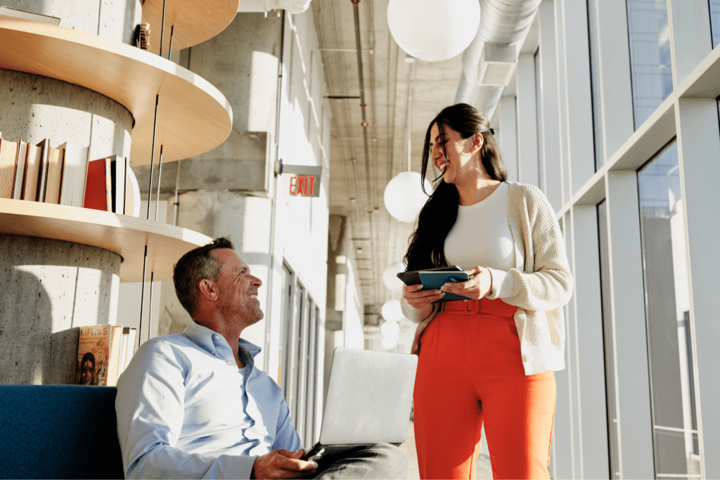 Employees conversing in a modern office environment.
