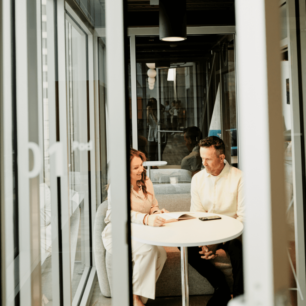 Two employees go over a project plan in a contemporary office setting.