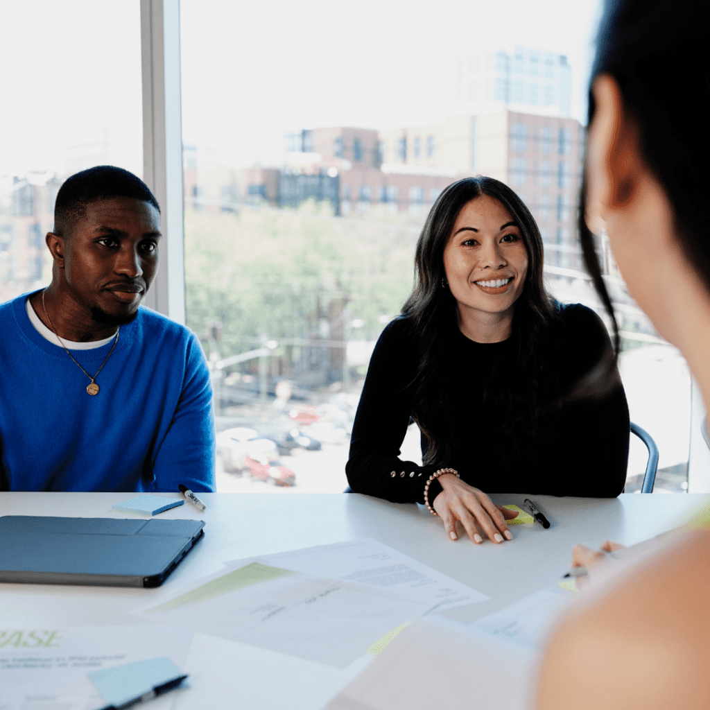 Three work colleagues collaborate around a conference room table.