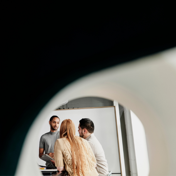 Three colleagues work together in a conference room setting