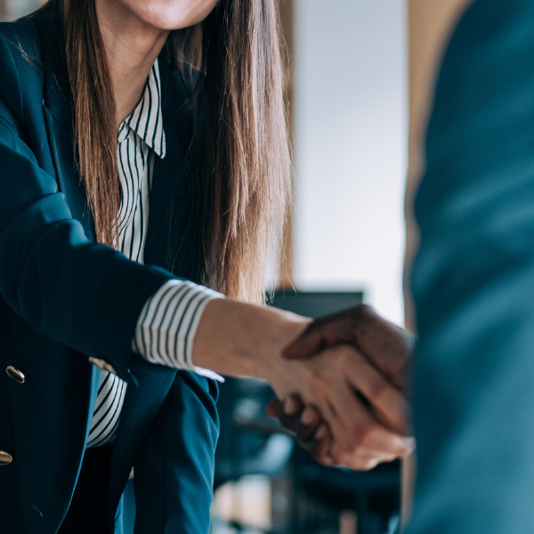 Hiring manager and job candidate shake hands at the start of an interview.