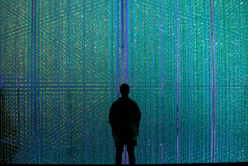 A person stands in front of a glowing digital display, representing AI-powered Salesforce implementation with human oversight, secure workflows, and controlled automation.