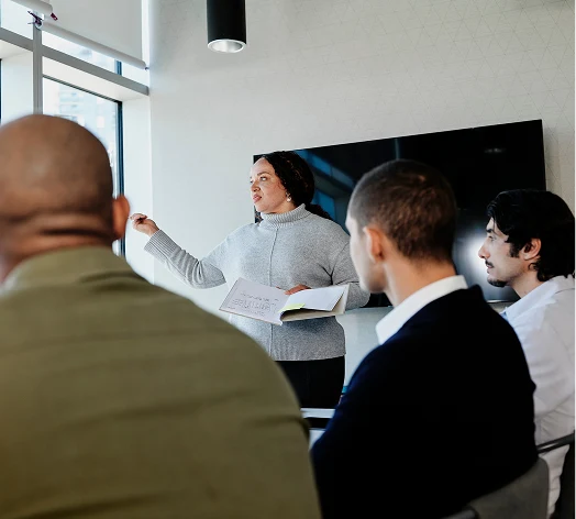 People in a conference room listening to a speaker.